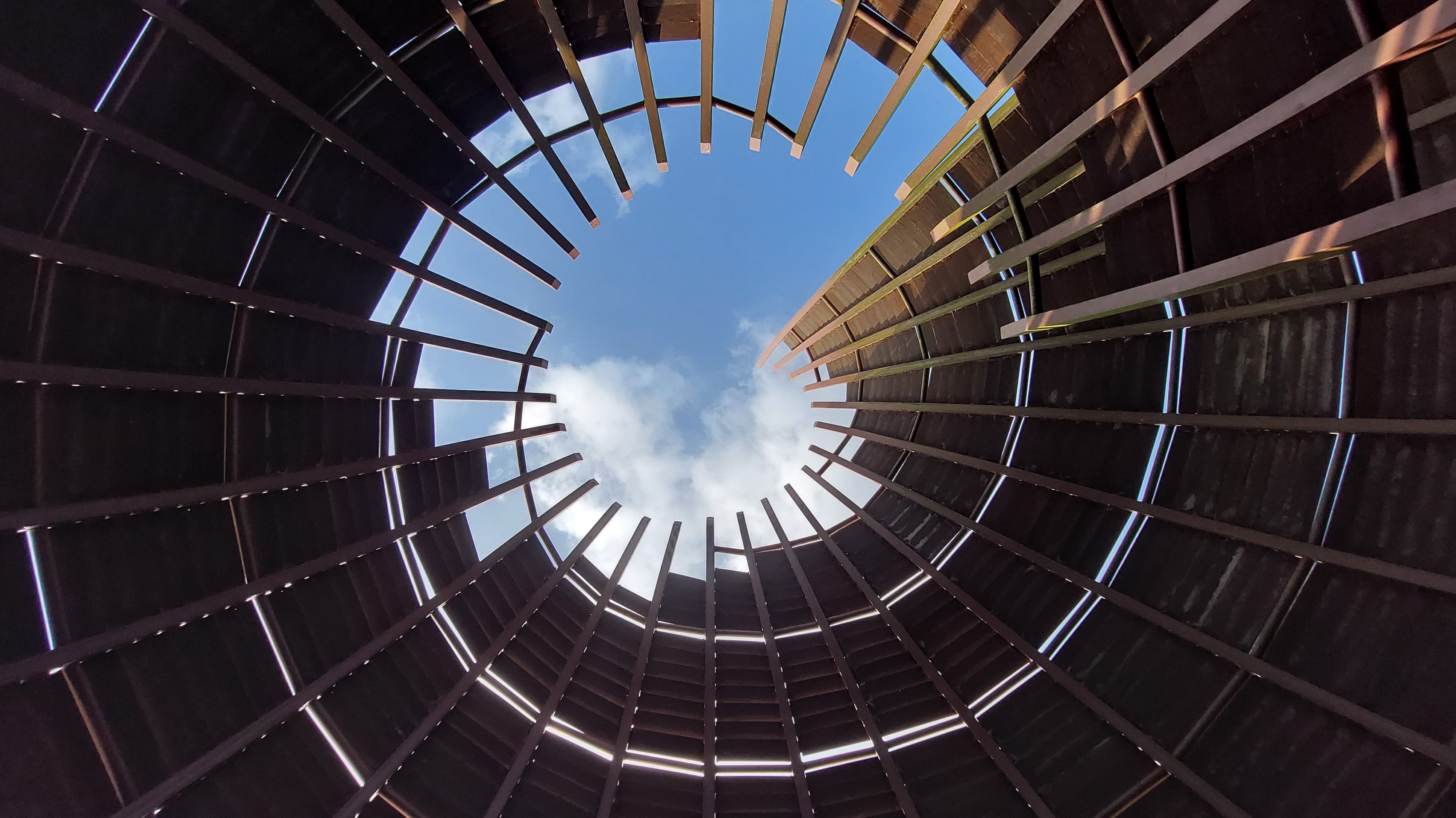 Upward view through a radial timber architectural structure