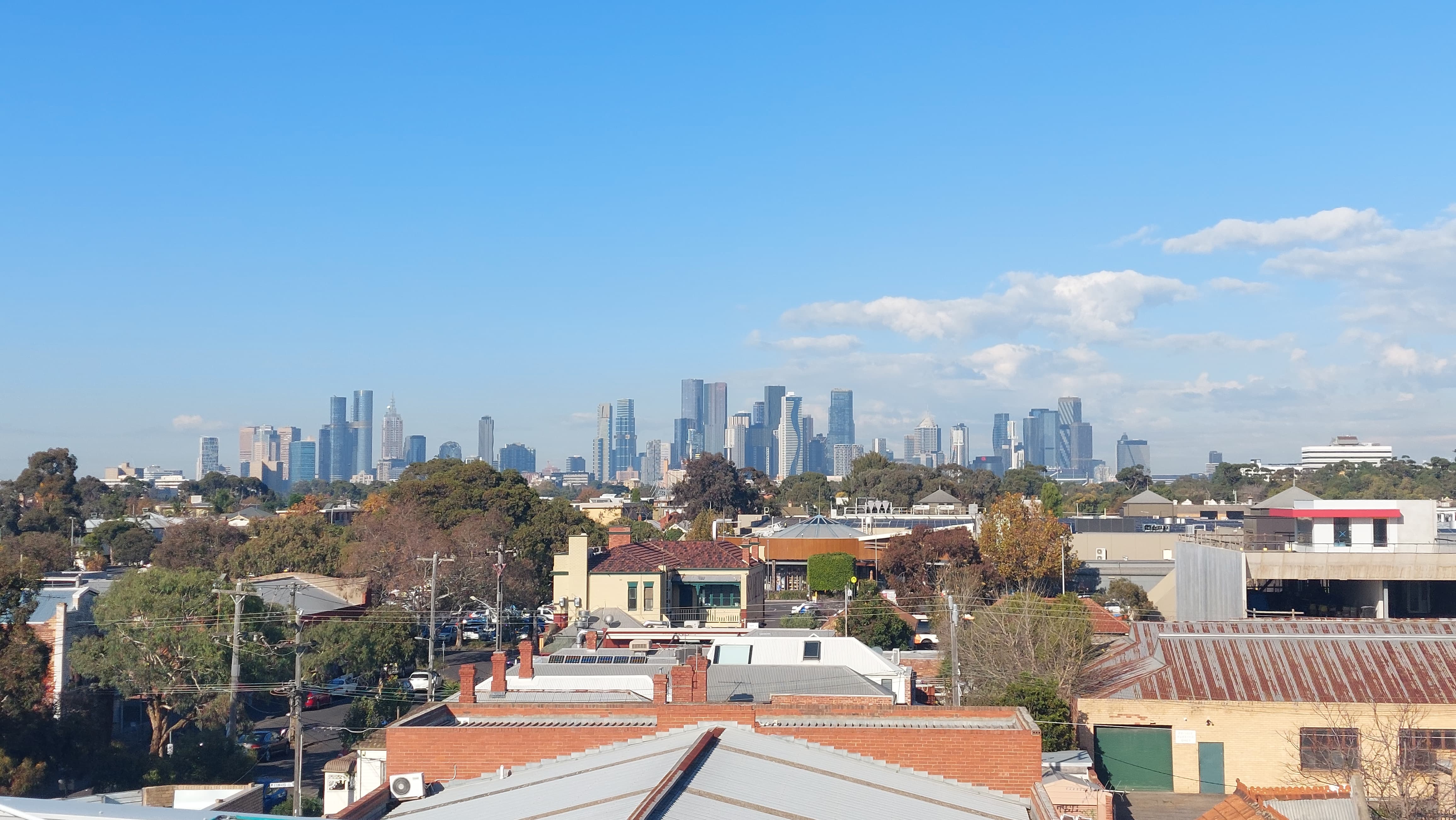 Melbourne city skyline on a clear day above treetops