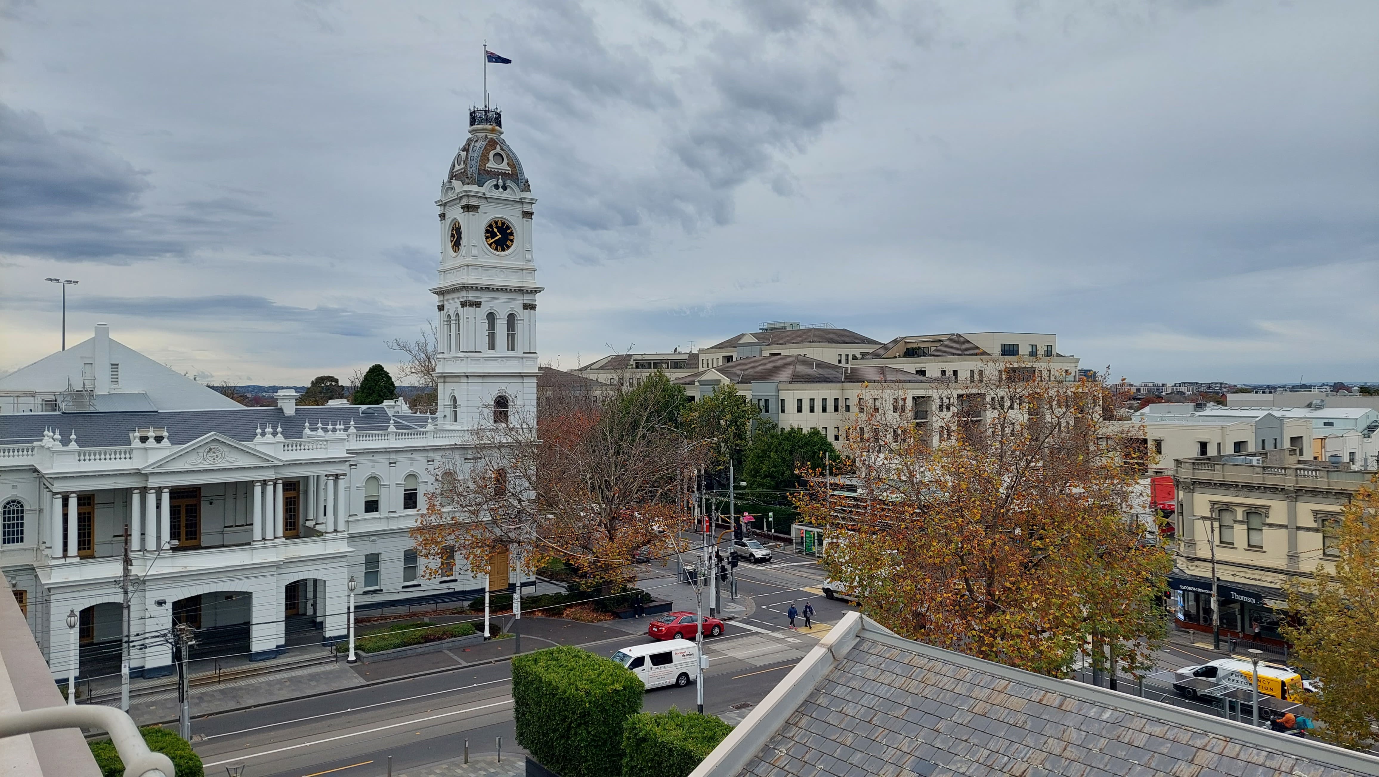 Historic civic building with clock tower at a city intersection